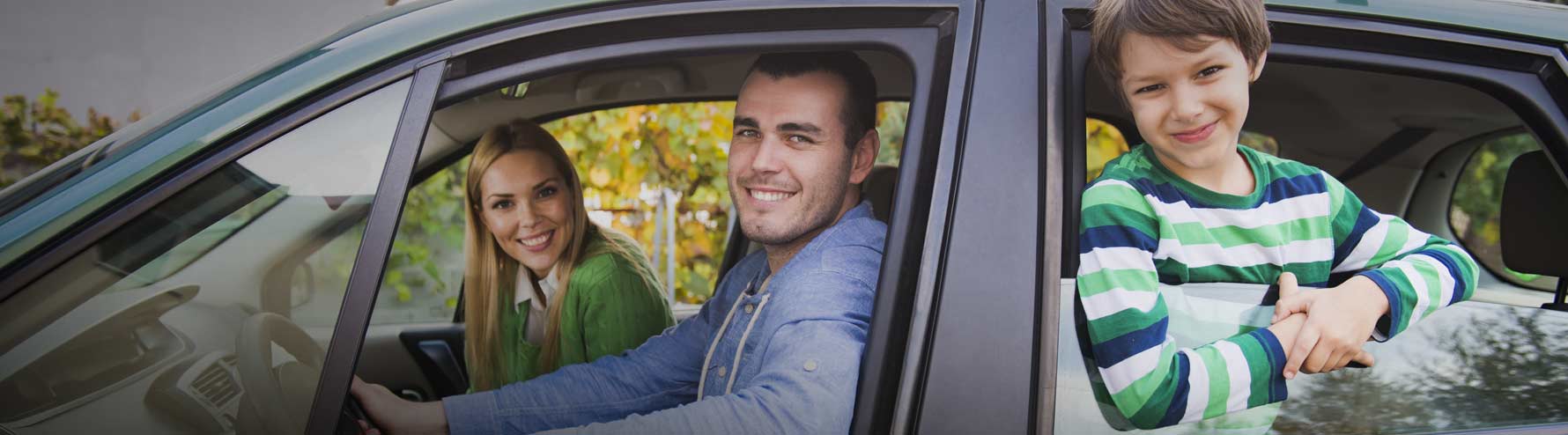 Family in car, smiling out of the windows